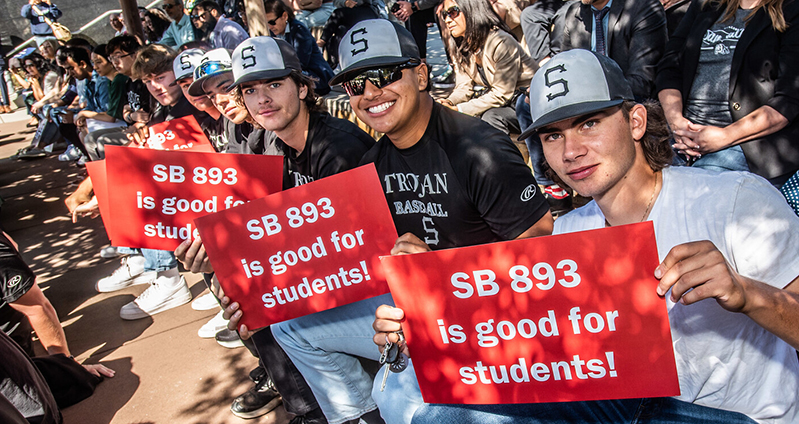 SMCCCD students with signs saying "SB 893 is good for students"