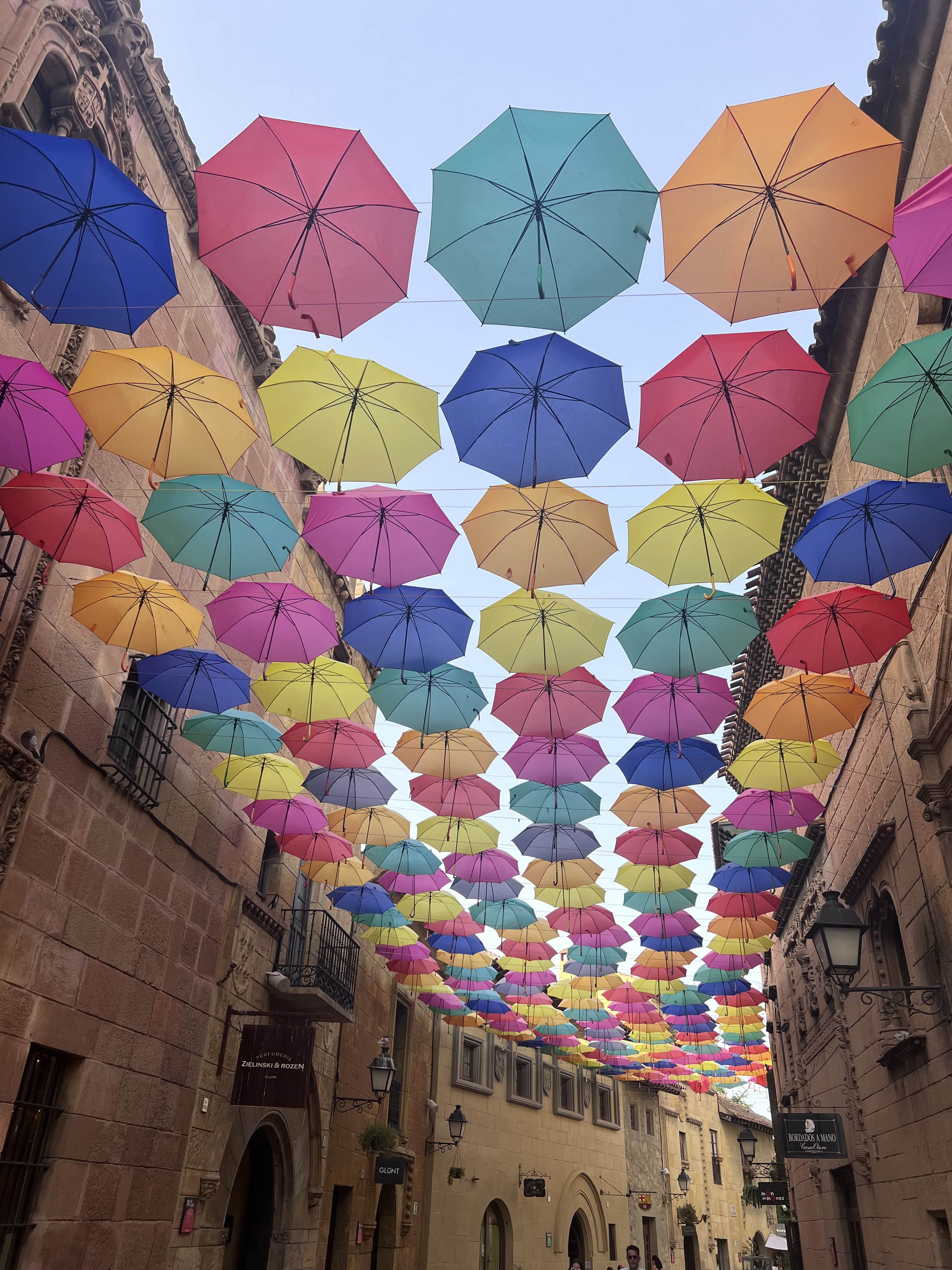 a walkway under colorful umbrellas