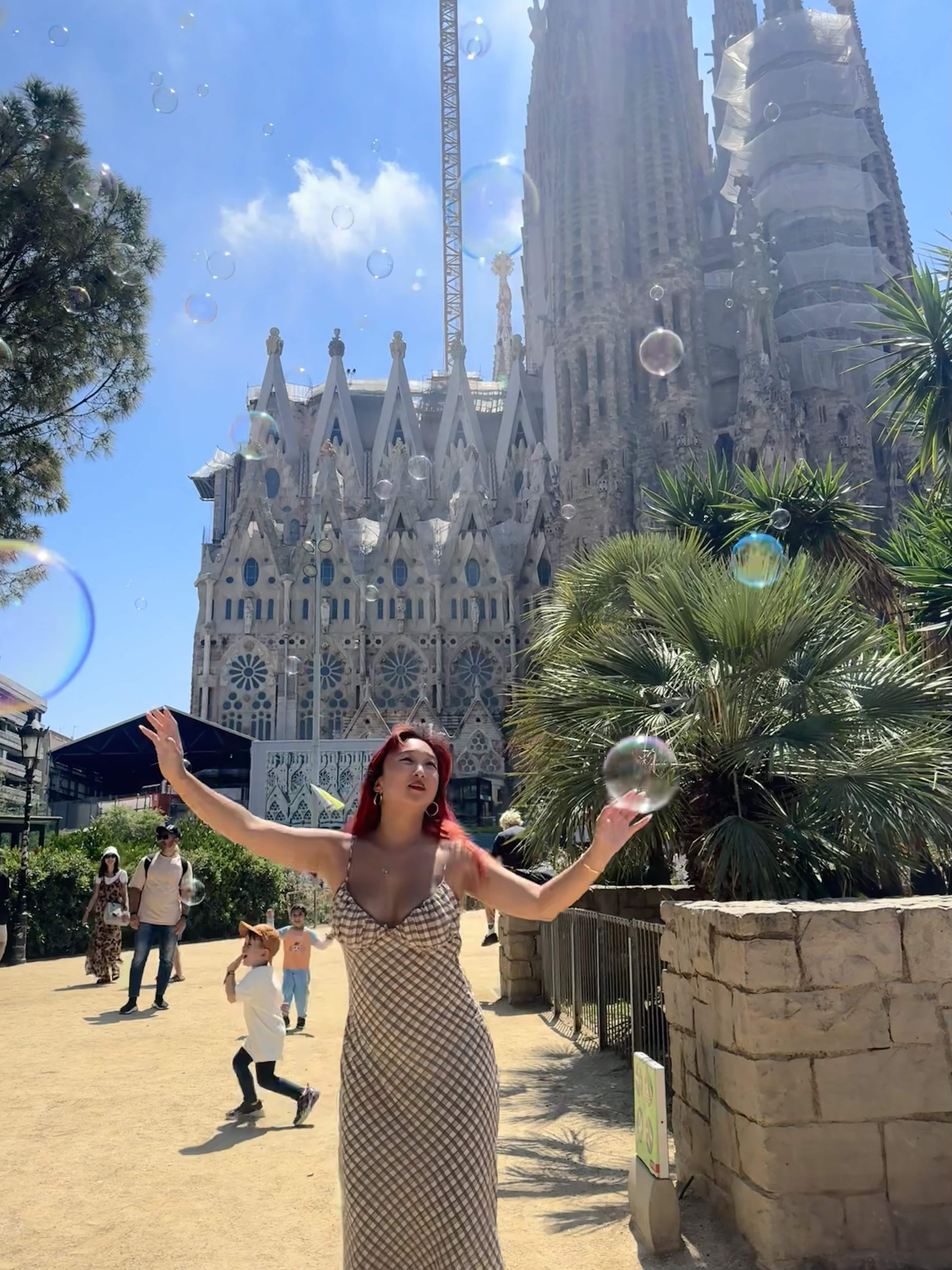 student with bubbles posing in front of the Sagrada Familia